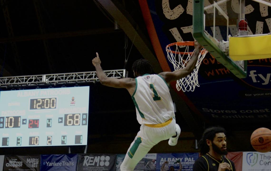 Patroons player hanging off rim of basket